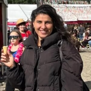 United Vision Türkiye Development Manager Mrs. Merve Gökü standing with smiling face wearing black winter clothes carrying ice-cream in one hand